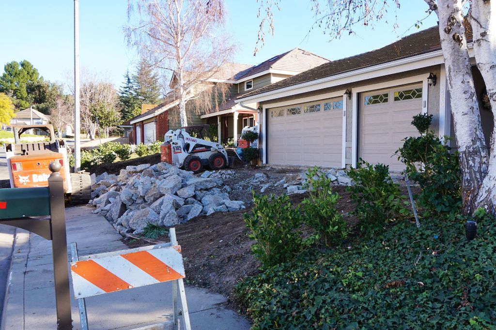 Barricaded driveway with demolition spoil awaiting haul-off
