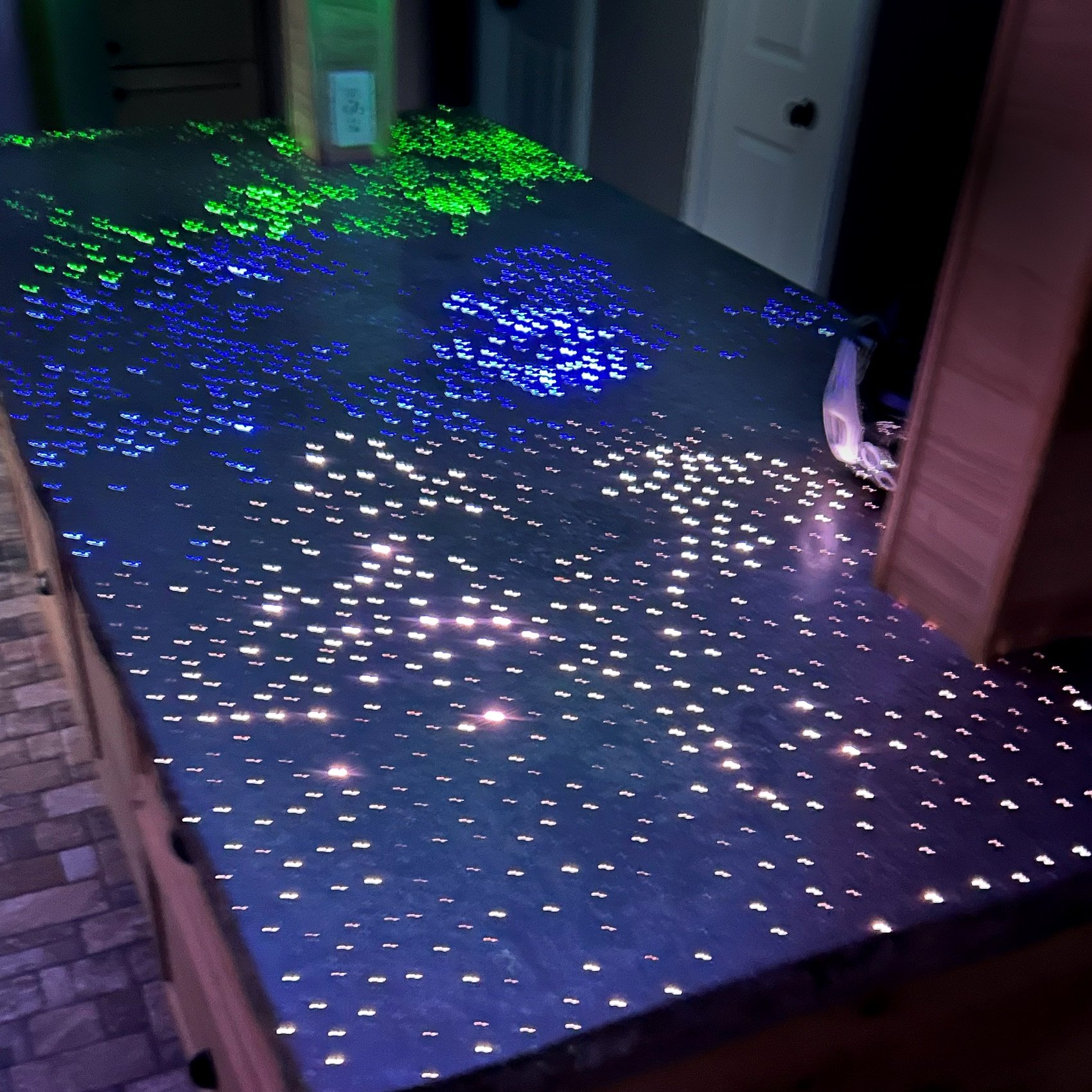 Fiber-optic concrete countertop running three colors at once, green, blue and white zones set into the polished slab