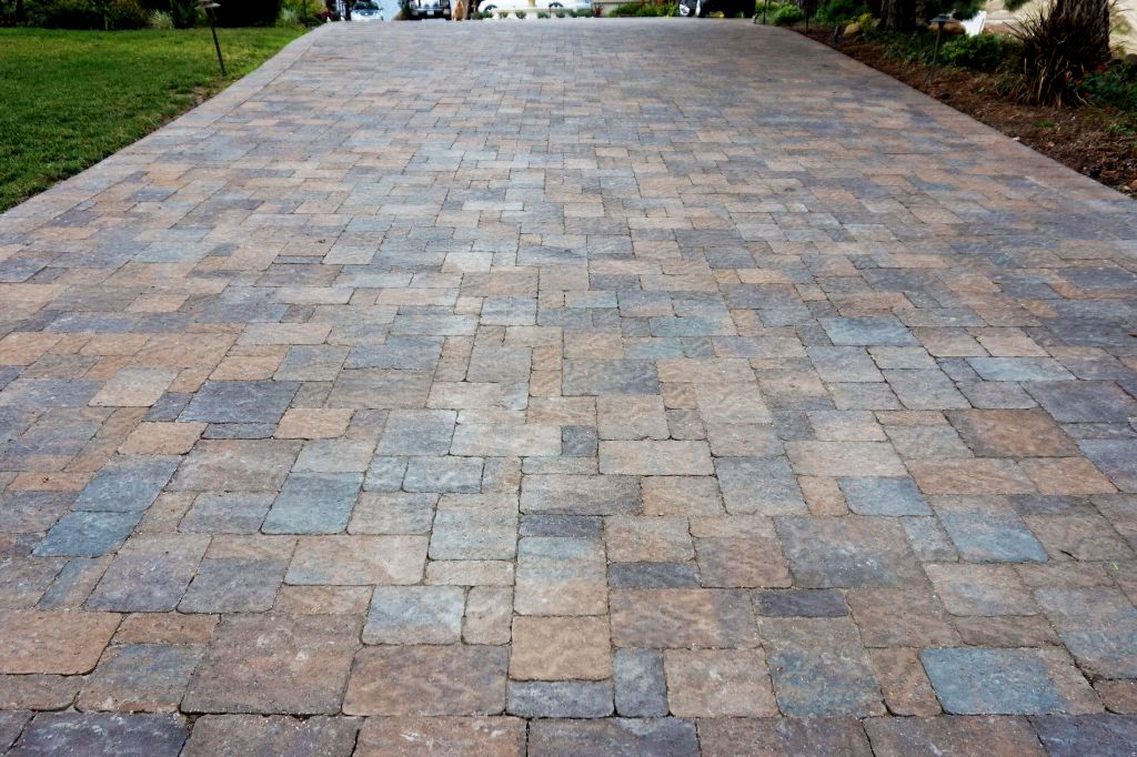 Paver driveway in tumbled gray and tan units, laid the full width of the lot and running back to the lawn