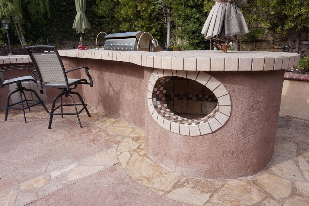 Built-in pizza oven set into the stucco surround of the outdoor kitchen counter