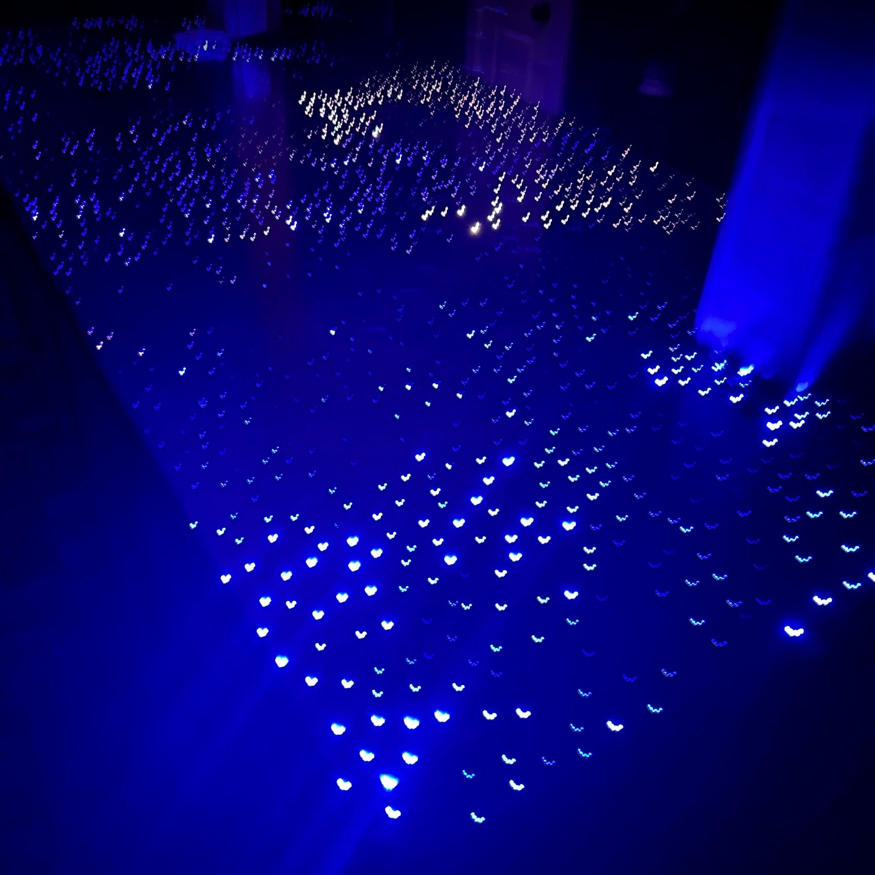 Fiber-optic concrete countertop lit at night, hundreds of fiber ends cast into the slab reading as a field of blue and white stars