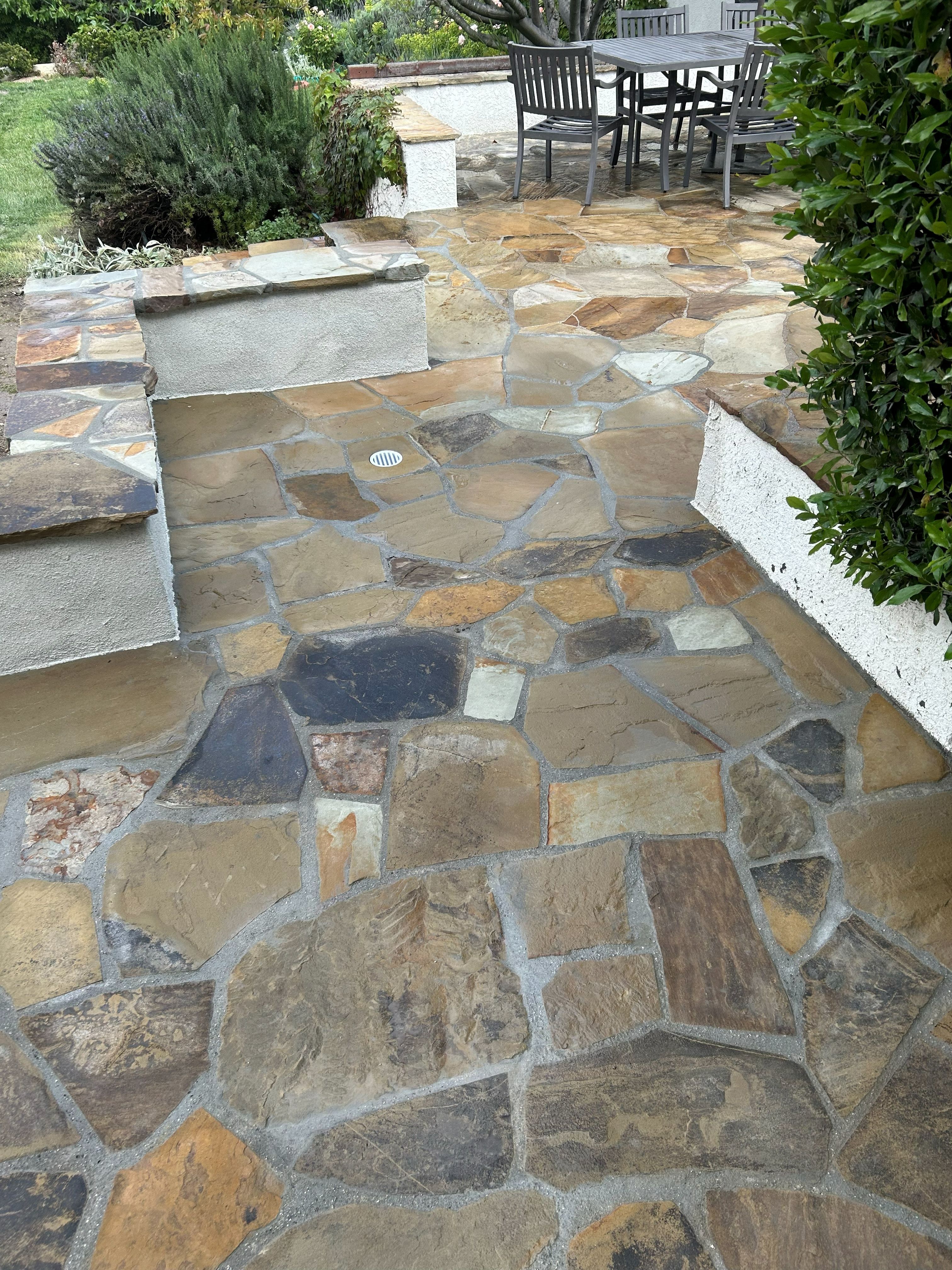 Flagstone patio with stepped changes of level and a rendered seat wall