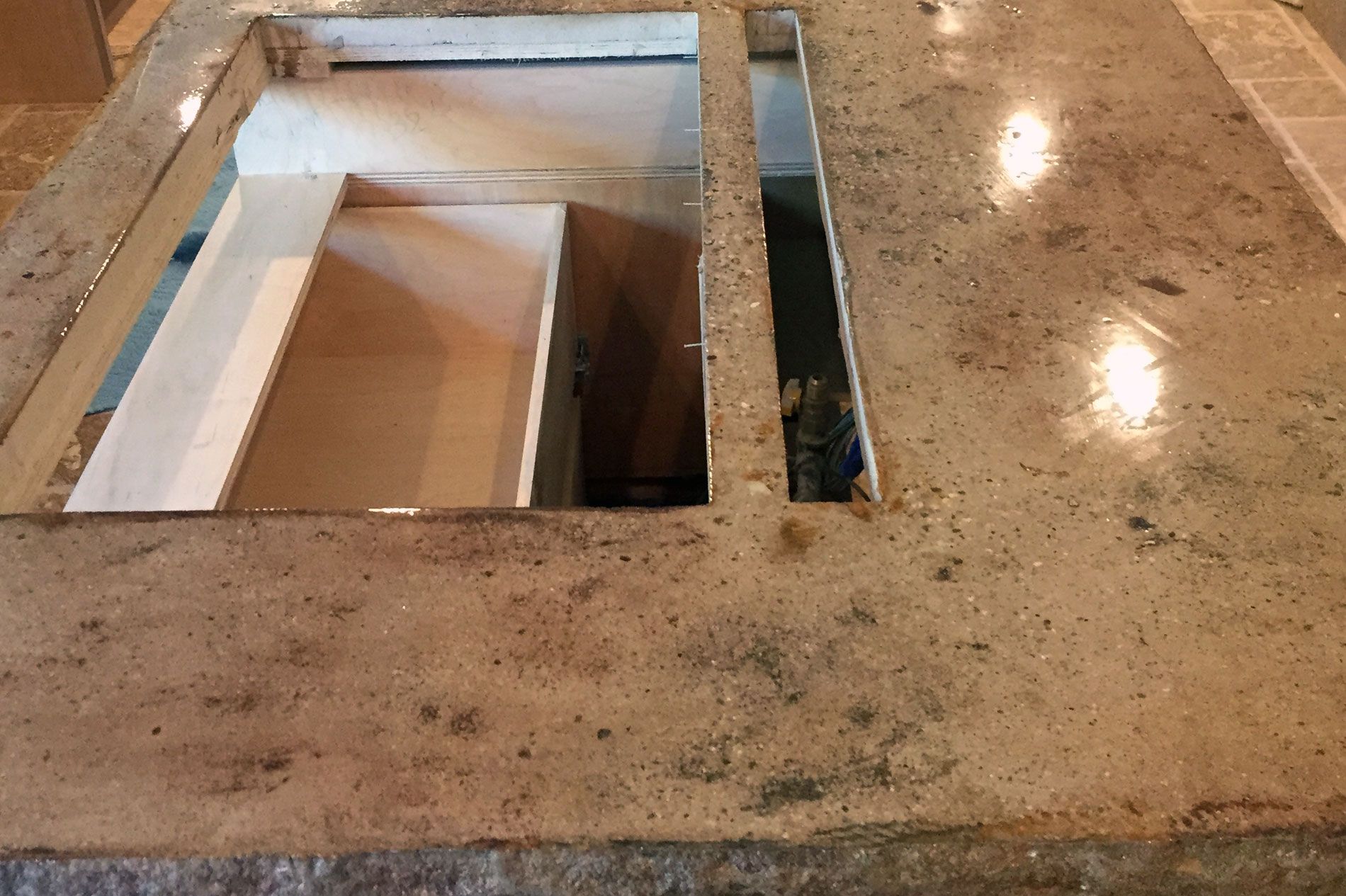 Polished concrete countertop cast in place with its sink and appliance openings already formed