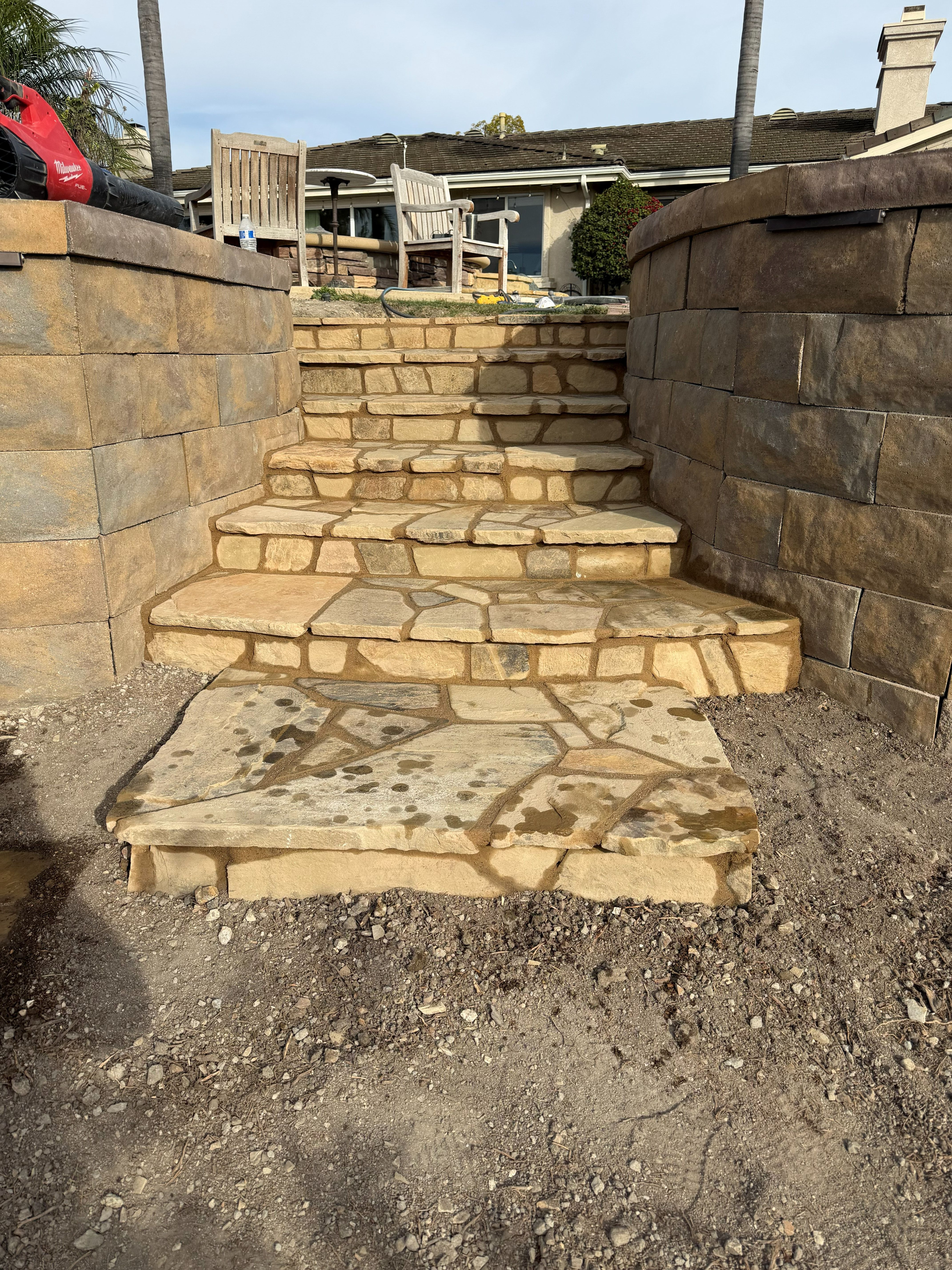 Sandstone steps rising between curved stacked-stone retaining walls
