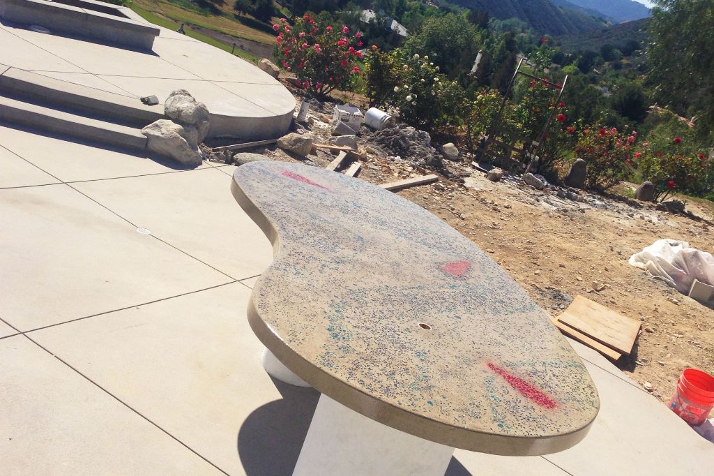 The same freeform slab from the side, showing the cast edge profile and the polished glass aggregate