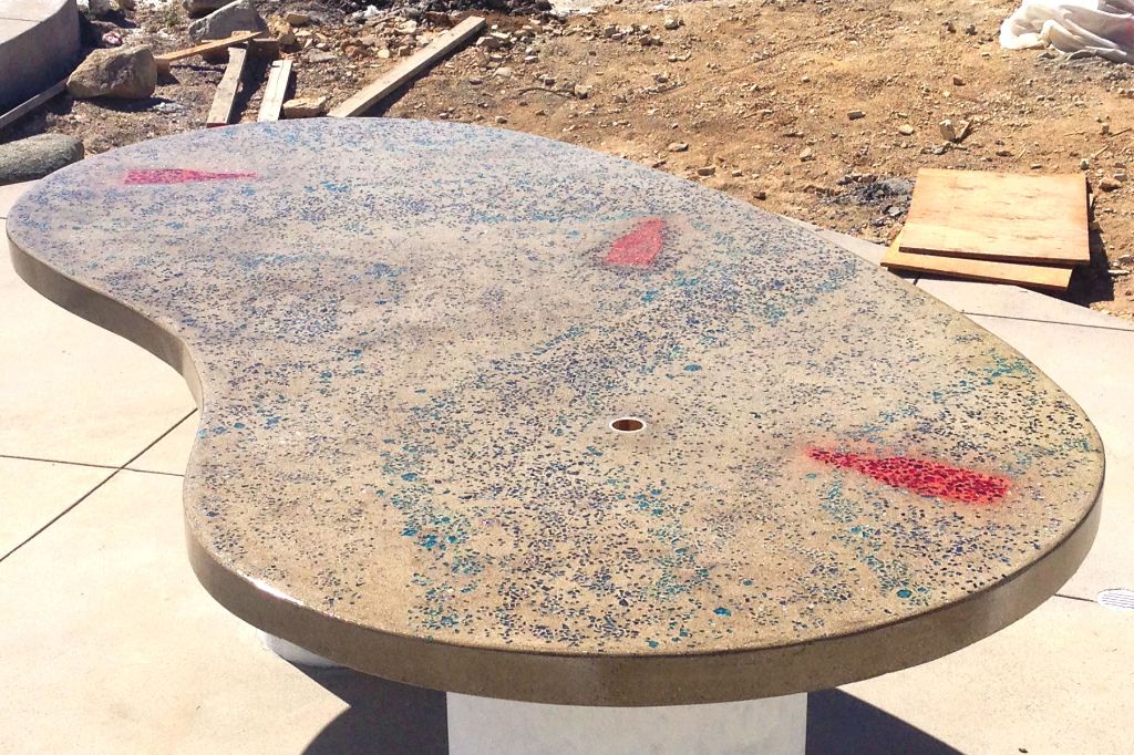 Freeform concrete countertop slab cast with colored glass aggregate, on site before it was set in place