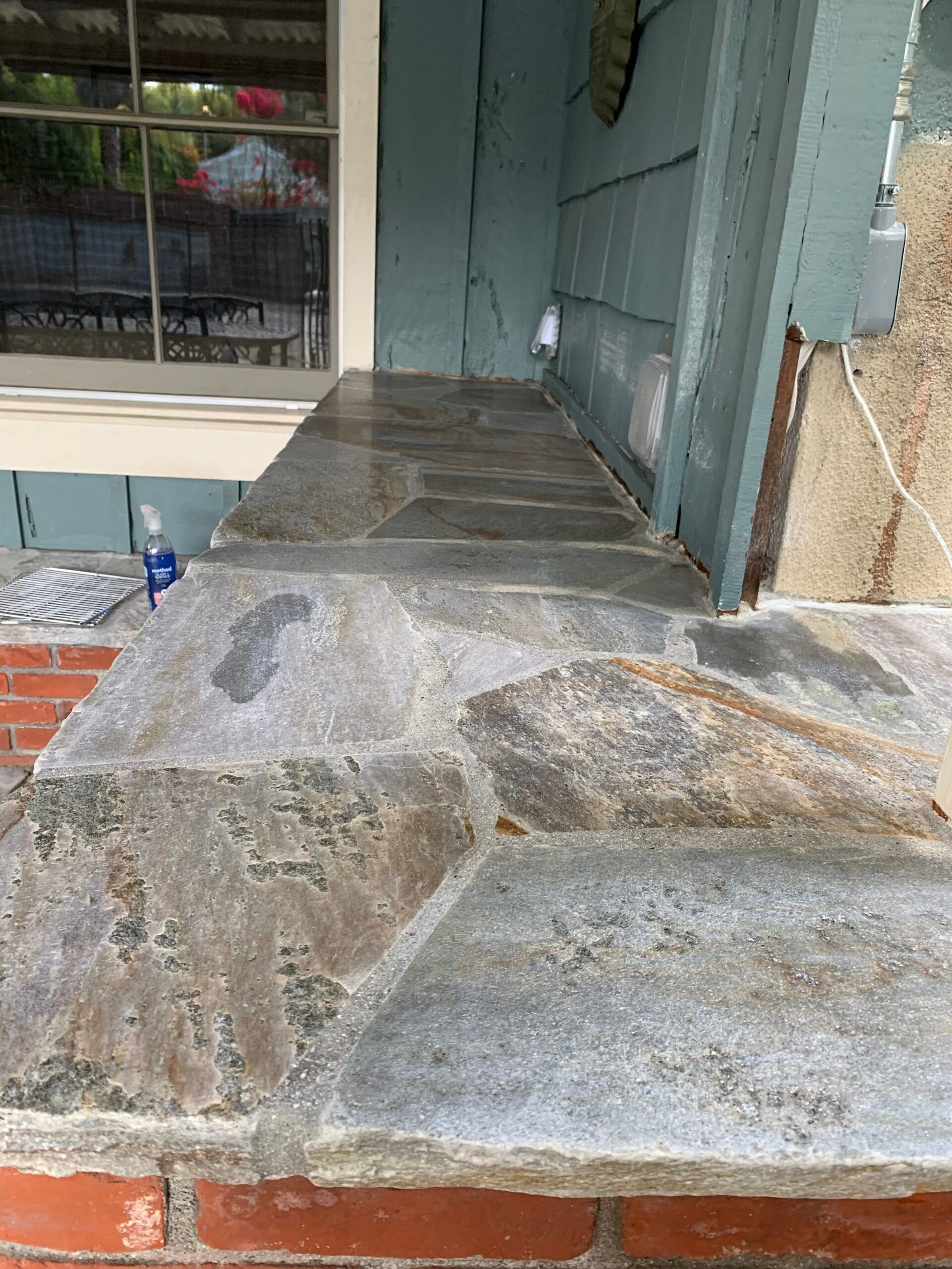 Outdoor bar counter topped with cut flagstone over a red brick base