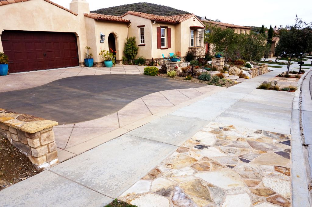 Concrete driveway and flagstone walkway in front of a Spanish-style Conejo Valley home