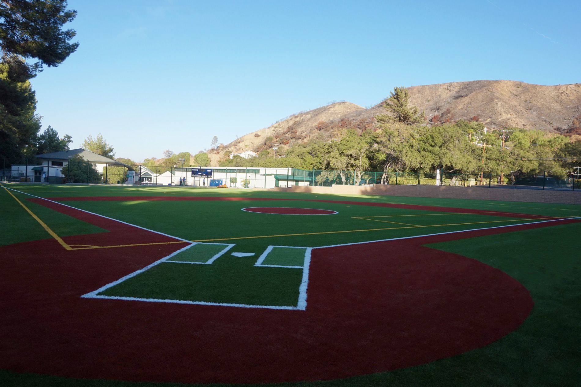 The finished Robertson Family Field diamond at Viewpoint School, Calabasas, red clay-colored infield and green turf under the hills