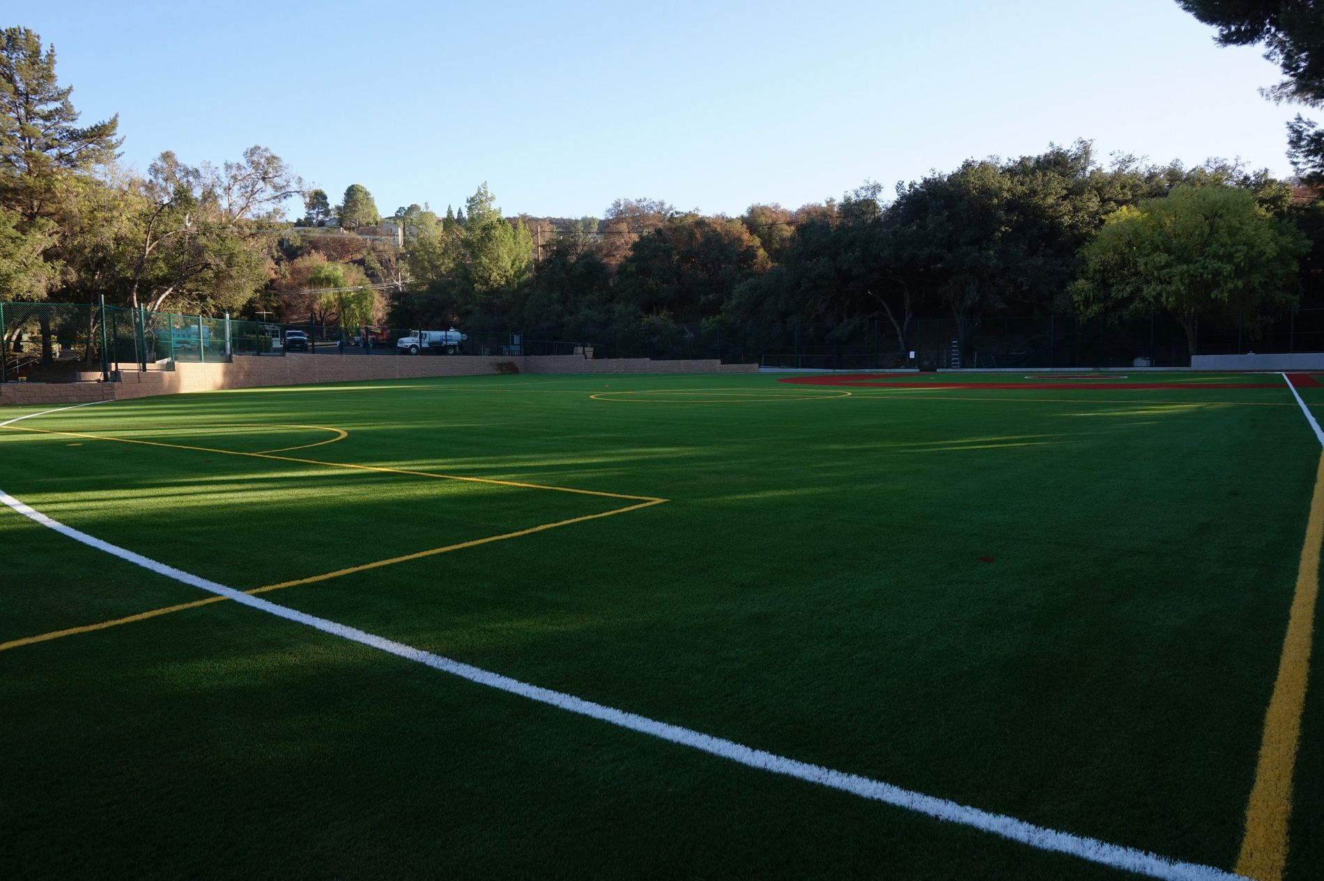Outfield turf and painted foul line running out toward the trees at Viewpoint School